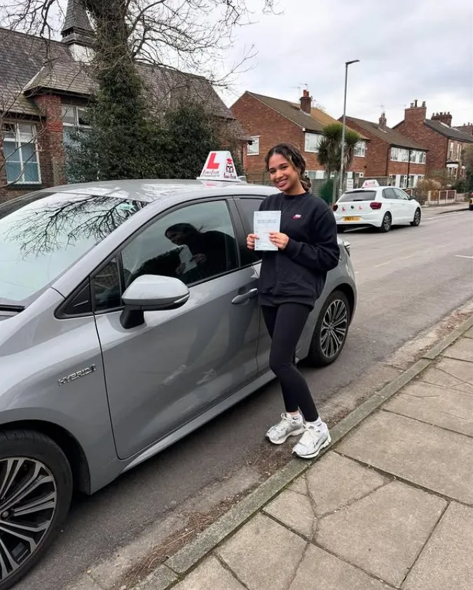 Daniel with their pass certificate beside a Learn Local car
